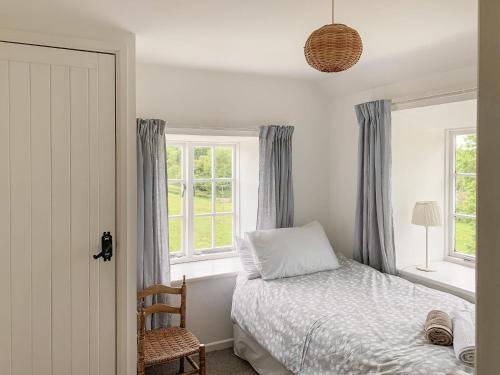 Aston InghamMarshalls Farm的一间卧室设有一张床和两个窗户。