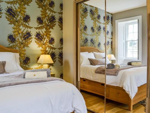 布莱尔阿瑟尔Riverside Cottage的一间卧室配有两张床和镜子