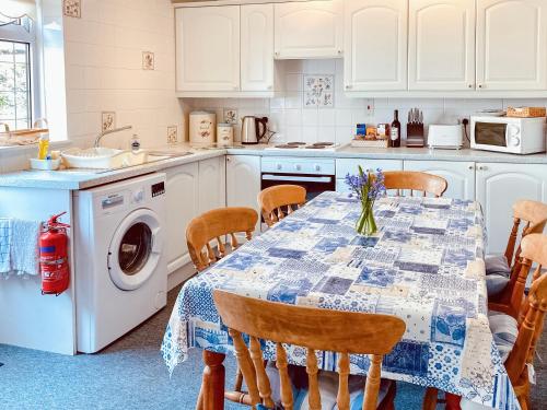 卡兰斯拓克The Haven的厨房配有桌椅和洗衣机。