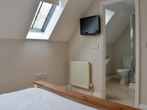 马托克Hollies Cottage 16 - Uck4539的卧室配有一张床,墙上配有电视。
