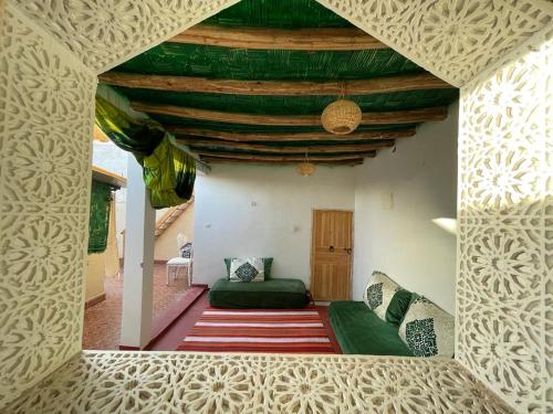 马拉喀什Riad Mama Toutou的客厅设有绿色沙发和天花板