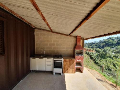 圣若泽-杜巴雷鲁Casa Container na Serra da Bocaina的一个带炉灶和屋顶的户外厨房
