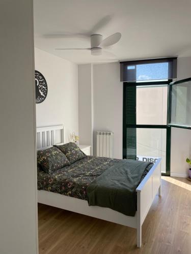 特拉萨Acogedor apartamento Vallparadís con parking的一间卧室配有一张床和吊扇