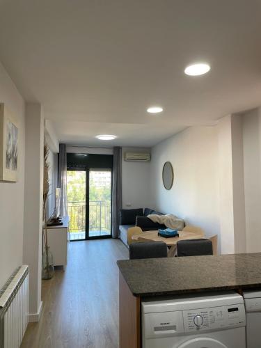 特拉萨Acogedor apartamento Vallparadís con parking的一间带沙发的客厅和一间客厅。