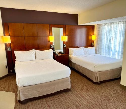 明尼阿波利斯明尼阿波利斯市中心旅行者酒店的酒店客房设有两张床和窗户。
