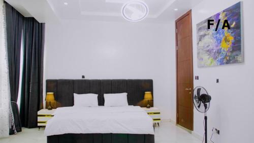 伊凯贾Favourite Luxury 2 Bedroom Apartment的一间卧室配有一张带白色床单的大床