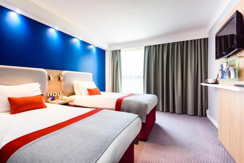 朴次茅斯快捷假日朴茨茅斯冈沃夫码头酒店的酒店客房设有两张床和一台平面电视。