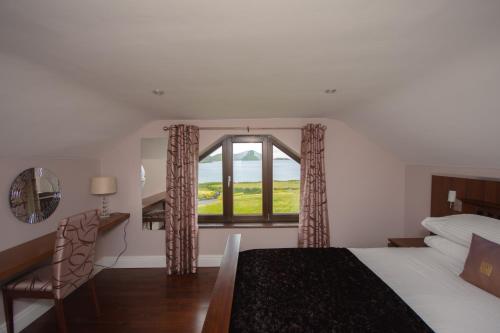 凯尔西温Fuchsia Lodge - New Luxury 5* Beachside Lodge with Sauna - 4 beds ensuite - Spectacular Location的一间卧室配有一张床、一个窗口和一张书桌