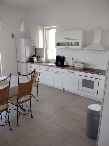 KápolnásnyékTandem apartman的厨房配有白色家电和桌椅