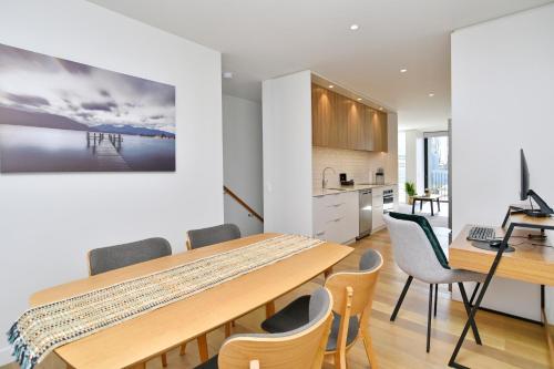 基督城Worcester Terrace Seven - Christchurch Holiday Homes的厨房以及带木桌和椅子的用餐室。
