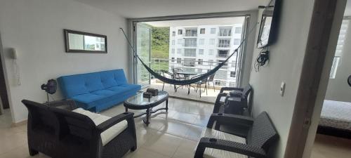 吉拉尔多特Aqualina Orange Apartamento Piso 6 Vista a Piscina 3 Habitaciones的客厅配有蓝色的沙发和吊床