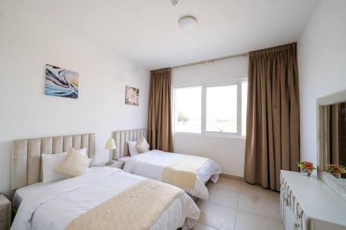 迪拜Elegant 2BR near Palm Jumeirah - 6 Min Drive的酒店客房设有两张床和窗户。