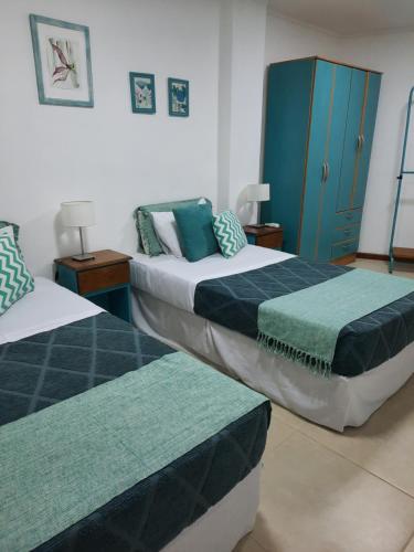 伊瓜苏港Las Arecas - 3° B的一间卧室设有两张床和蓝色的橱柜