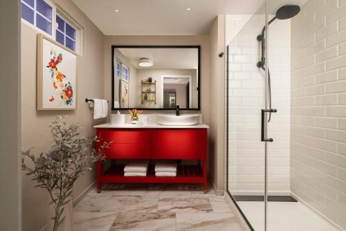 门洛帕克The Cottages Hotel的一间带红色水槽和淋浴的浴室