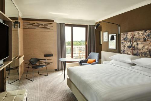 伦敦伦敦摄政公园万豪酒店的酒店客房配有一张床、一张书桌和一台电视。