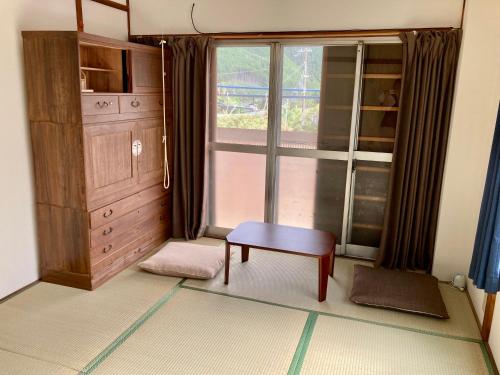 田边市民宿 和合 Minshuku WAGO的一间带椅子、窗户和橱柜的房间