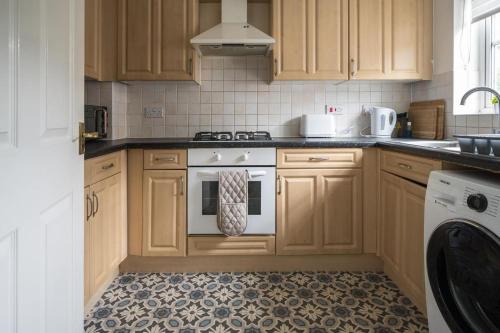 梅德斯通Maidstone villa 3bedroom free sports channels park的厨房配有木制橱柜和白色烤箱。