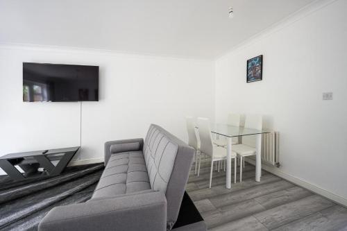 梅德斯通Maidstone villa 3bedroom free sports channels park的客厅配有沙发和桌子