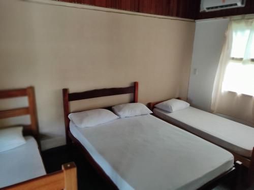 乌巴图巴Chales Mata Atlantica De Ubatuba的小型客房 - 带2张床和窗户