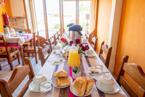 奇瓦伊Sonqo Killa del Colca的长桌,上面有面包和橙汁