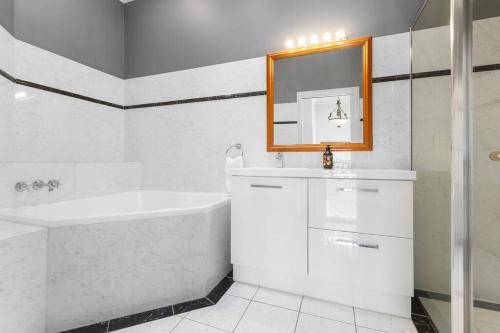 纽卡斯尔Classic Elegance on The Hill的带浴缸、水槽和镜子的浴室