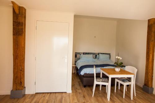 海伦多伦Bed And Breakfast Geertruidahoeve的卧室配有一张床和一张桌子及椅子