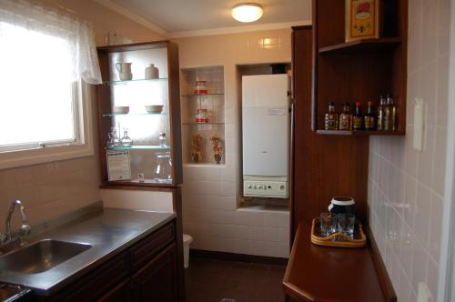 马德普拉塔Torres de Manantiales Apart Hotel的一间带水槽和冰箱的小厨房