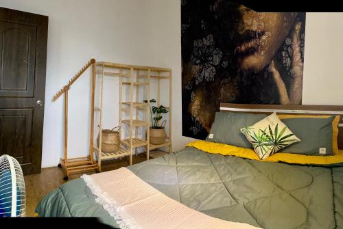 芽庄Mường Thanh Nha Trang-Anna House的卧室配有一张床,墙上挂有绘画作品