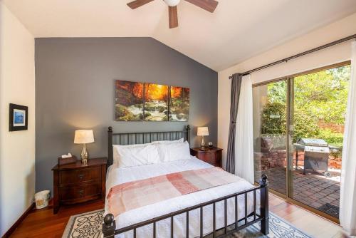 塞多纳Uptown Sedona Gem: 3-Bed Townhome with Majestic Views and Central Location的一间卧室设有一张床和一个滑动玻璃门