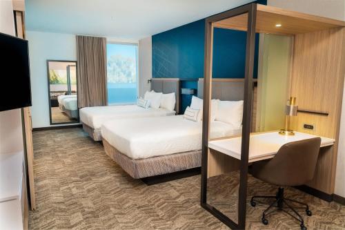 纽瓦克SpringHill Suites by Marriott Newark Fremont的酒店客房配有两张床和一张书桌