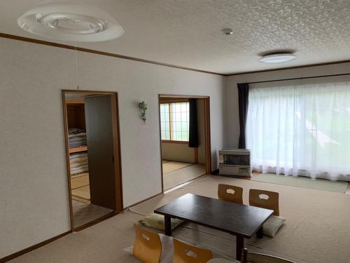 富良野FURANO UEDA HOUSE的客厅配有桌子和窗户