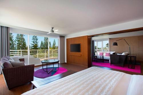 努美阿努美阿子午线度假酒店及Spa的一间卧室设有一张床和一间客厅。