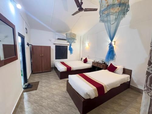 索拉哈Ama Garden Sauraha的酒店客房,设有两张床和一张沙发