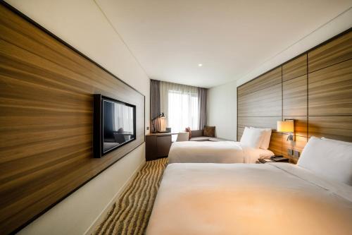 金浦Hotel Marinabay Seoul的酒店客房设有两张床和一台平面电视。