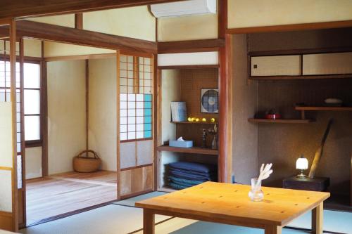 FuchisakiOkatei - Vacation STAY 35463v的一间设有桌子的房间和一间带书架的房间
