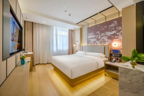 义乌义乌百德主题酒店的卧室配有一张白色大床和电视。