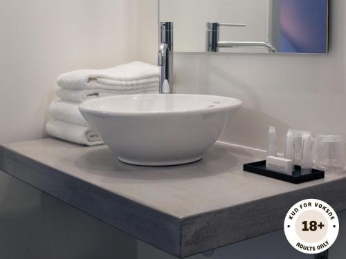 马斯塔尔Ærø Hotel - Adults only的浴室内一个柜台上的白色碗水槽