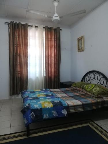 瓜拉弄宾Roomstay homestay Ahmad Rompin的一间卧室配有一张带彩色毯子的床