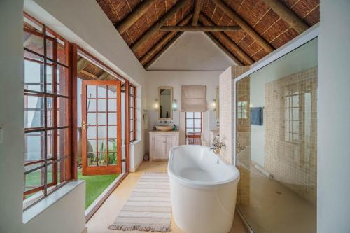 圣弗朗西斯湾Cottage on College的一间带浴缸的浴室,位于带窗户的客房内