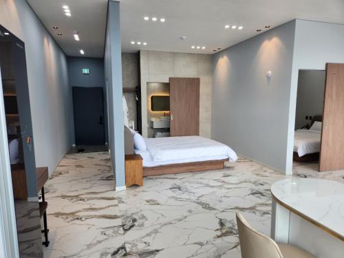 丽水市Suite Stay Yeosu的一间铺有大理石地板的卧室,配有一张床。