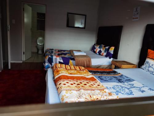 开普敦GALAXY BOSTON BELLVILLE的酒店客房设有两张床和电视。