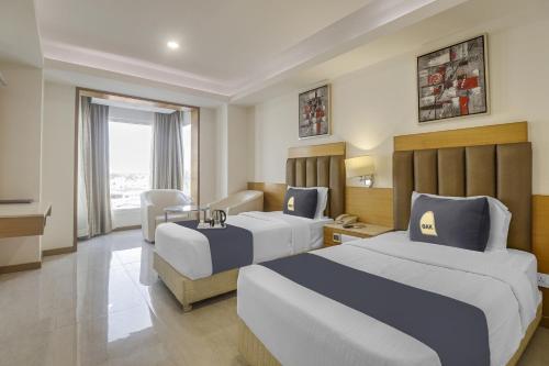 钦奈Palette - Hotel chennai le palace的酒店客房设有两张床和电视。