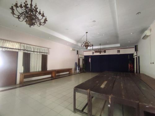 PurworejoCapital O 93024 Hotel Ganesha的大房间设有木桌和舞台