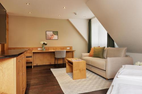 维尔茨堡Hotel Fischzucht - by homekeepers的客厅配有沙发和书桌。