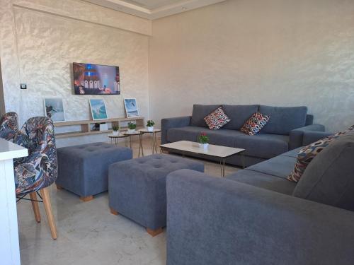 穆罕默迪耶vacance et confort les sablettes的客厅配有蓝色的沙发和桌子