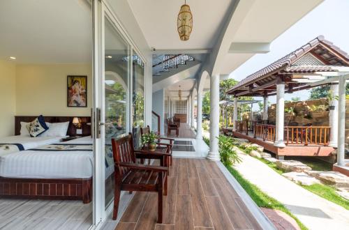 富国Suối Mây Phú Quốc Garden Resort - Full 24h Stay的主卧室设有一张床和一个阳台