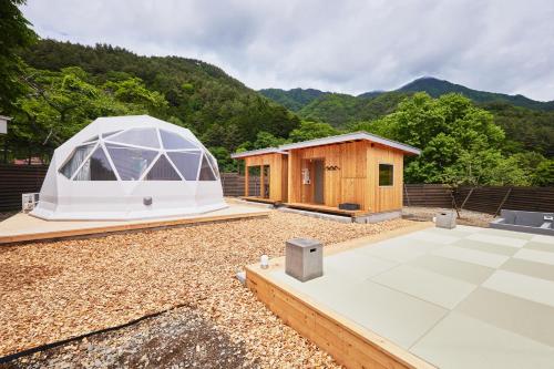 富士河口湖dots by Dot Glamping Suite 001的帐篷和小屋的背景是山脉