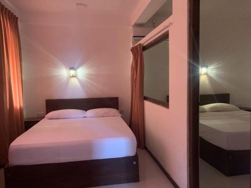 丹不拉Nature Rock Dambulla的一间卧室配有两张床和镜子