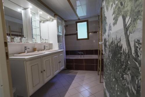 塞夫里耶Les Eaux Vives的浴室配有两个盥洗盆和浴缸。