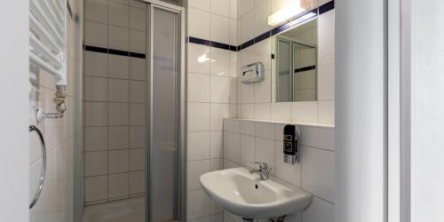 斯图加特A＆O斯图加特城市酒店 的白色的浴室设有水槽和淋浴。